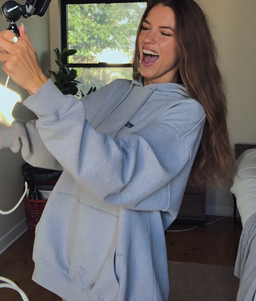 A creator laughing as she films herself at home