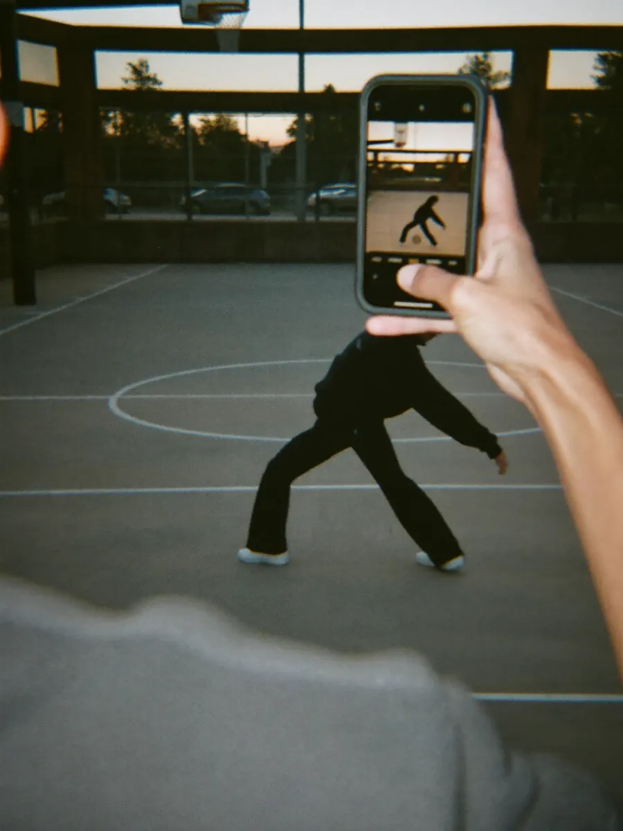 A dancer being filmed on a basketball court
