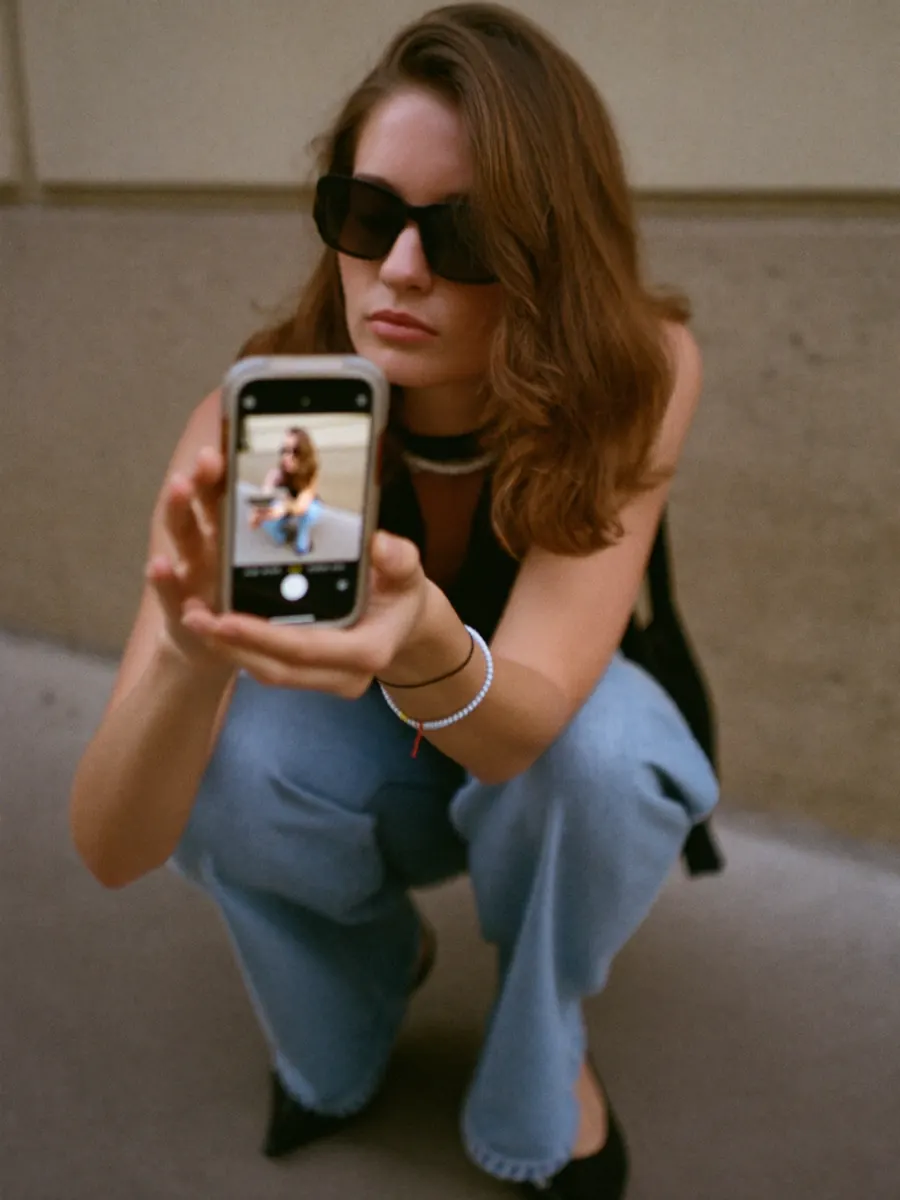 A creator filming with her phone on the street
