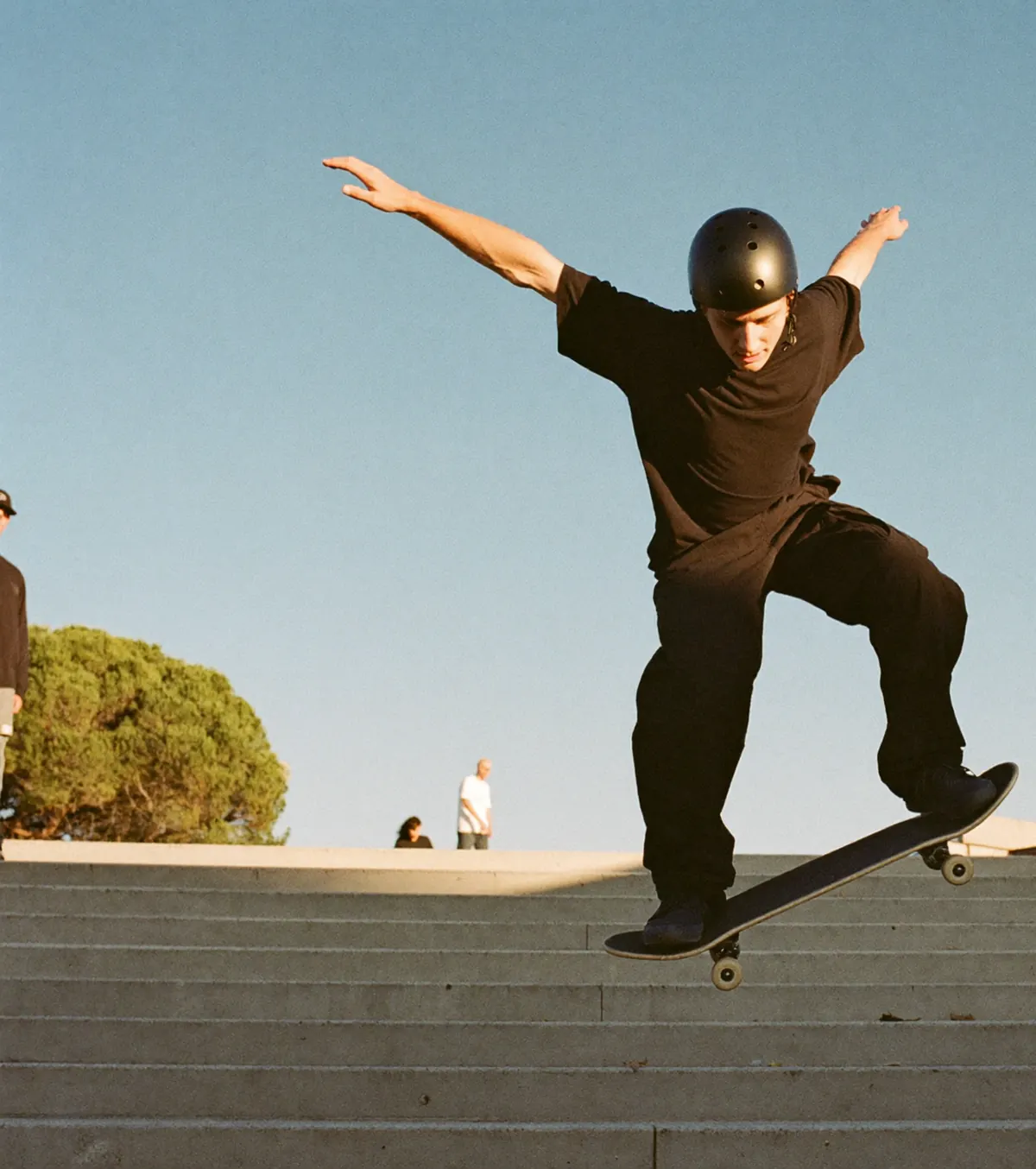 A skateboarder in mid-air above concrete steps