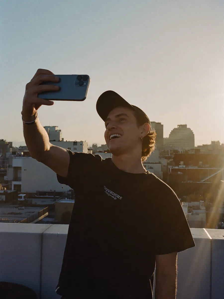 A creator filming himself on a rooftop at sunset
